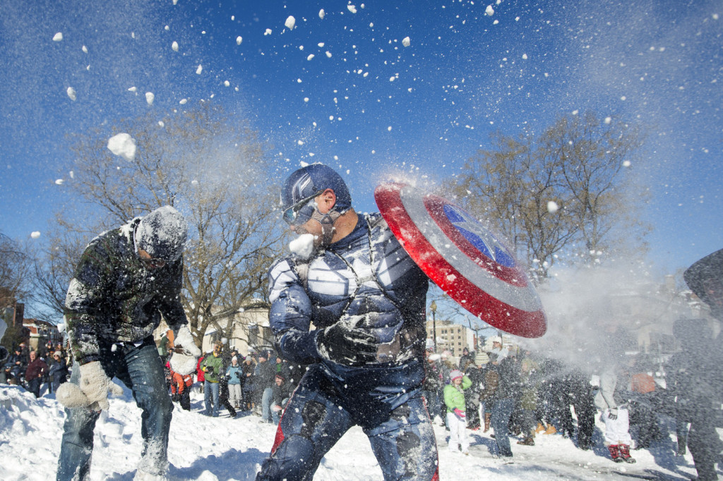 epa05123218 Jeff Dacanay (C), while dressed as Captain America, is pelted with snow during a snowball fight following a blizzard, at Dupont Circle in Washington, DC, USA, 24 January 2016. The nation's capital is beginning to recover from a major blizzard, Winter Storm Jonas, that dumped near-record amounts of snow in Washington DC. EPA/MICHAEL REYNOLDS